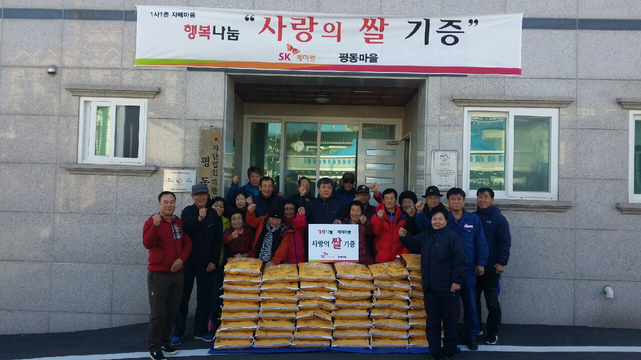 Description of the photograph: SK chemicals` employees including the plant manager of Ulsan Plant, Hwang Chun-hyeon (center) are donating their love rice at the Pyeong-dong Village community center. 