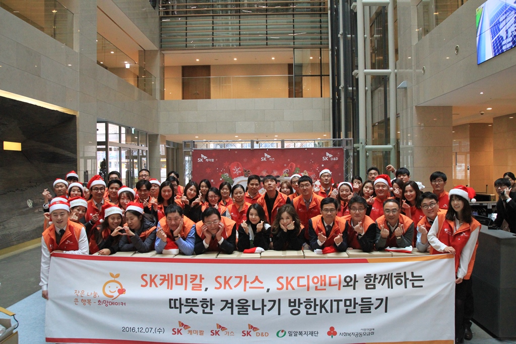 SK케미칼 한병로 대표(오른쪽에서 다섯 번째), SK가스 김정근 사장(왼쪽에서 다섯 번째)을 비롯한 구성원들이 희망 메이커 아동 가정에 전달할 방한 키트 450세트를 제작했다.