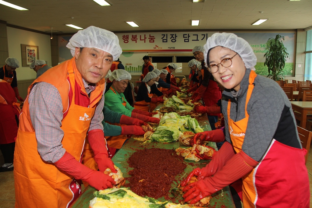 SK chemicals Ulsan Plant manager Hwang Chun-hyeon (left) makes kimchi along with Kim Bu-jin, leader of the Geonam Village Women`s Association, during this year`s kimjang event. 